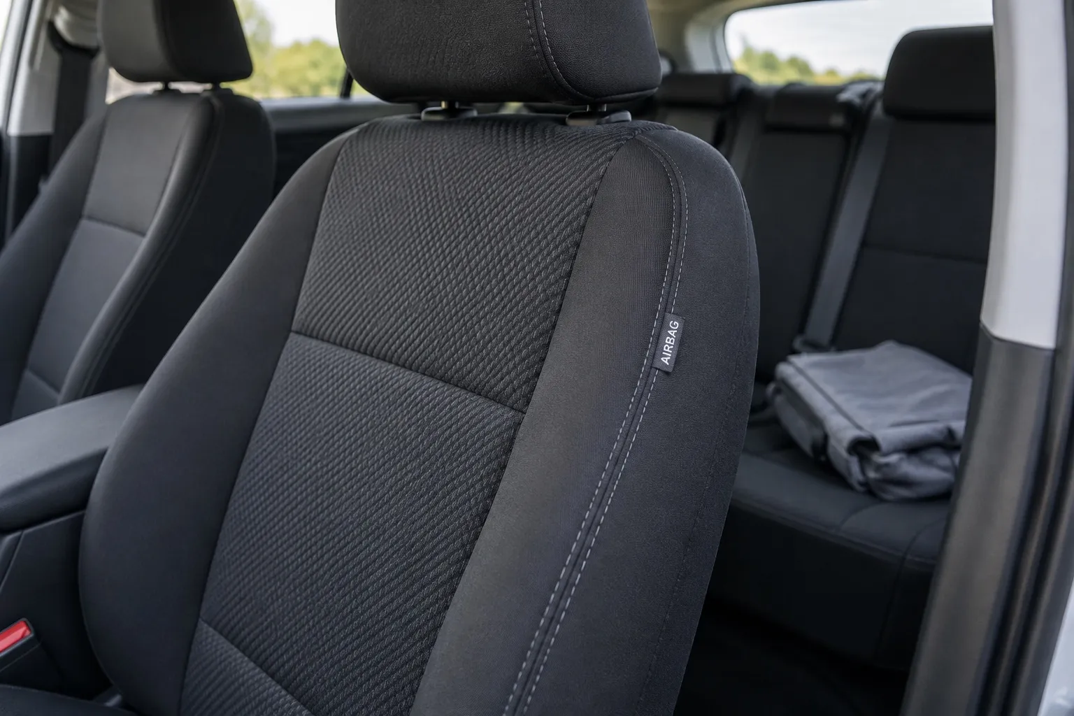 Боковая часть штатного переднего сиденья с биркой AIRBAG и отдельный сложенный чехол рядом