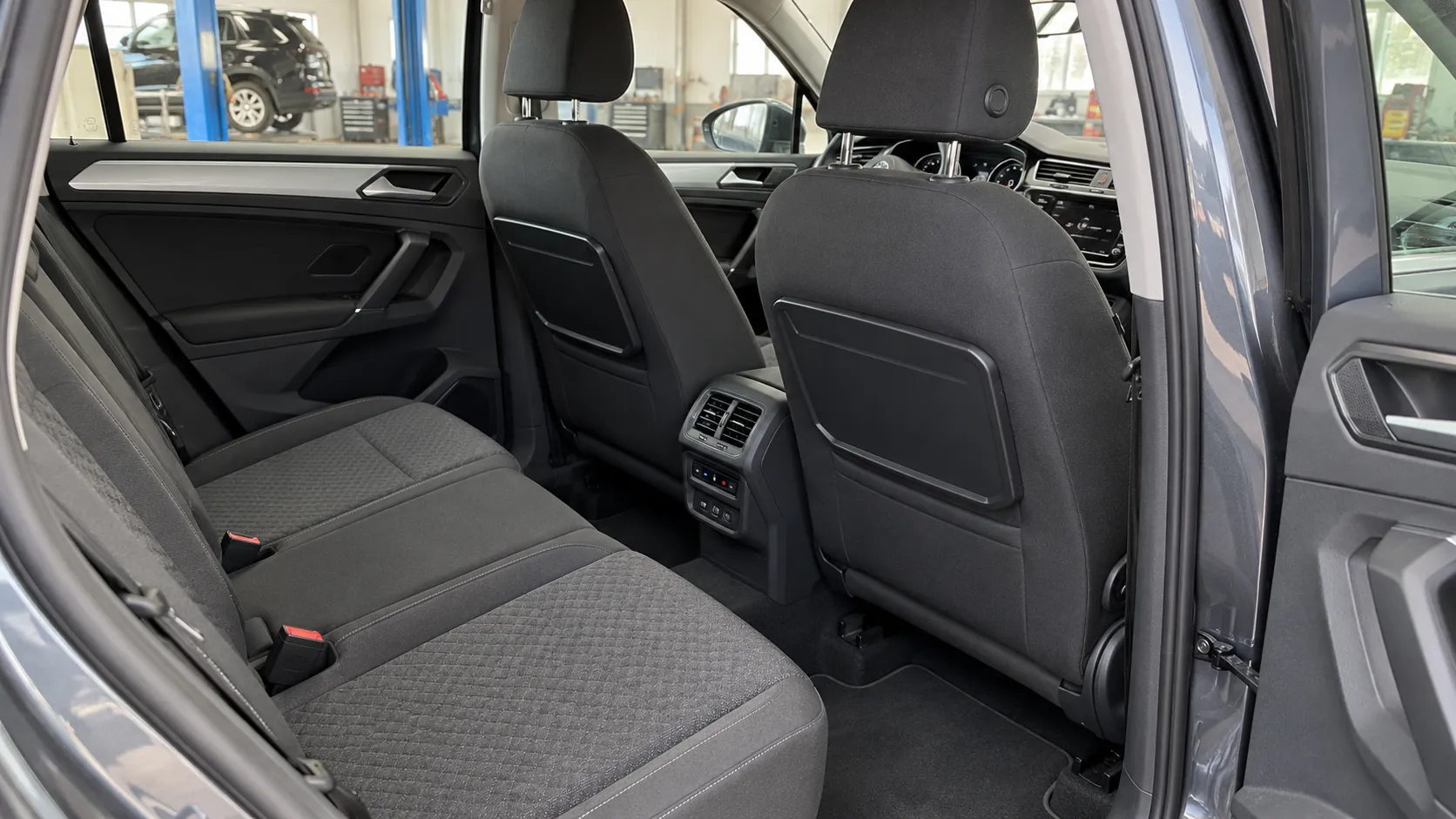 Задние дефлекторы и панель управления климатом в салоне Volkswagen Tiguan II